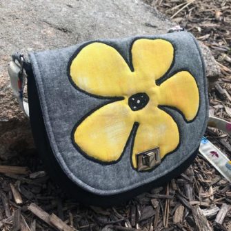 Angled view of the summery 'flower' motif That Flap Saddlebag - Andrie Designs